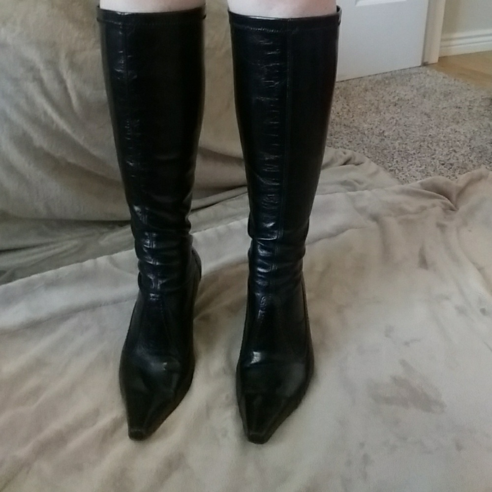 Black shiny knee high heeled boots.